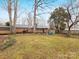 Spacious backyard showcasing a brick home, patio, seating area, and mature trees at 3350 Bonneville Dr, Charlotte, NC 28205