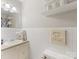 Bright bathroom featuring white tile, a vanity, storage shelf, and decorative 'Seat Yourself' sign at 3350 Bonneville Dr, Charlotte, NC 28205
