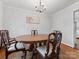 Traditional dining room featuring hardwood floors, natural light from a window, and a chandelier at 3350 Bonneville Dr, Charlotte, NC 28205