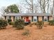 Charming brick ranch home with a red door, black shutters, and well-maintained landscaping at 3350 Bonneville Dr, Charlotte, NC 28205