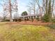 Brick home with landscaped front yard, black shutters, and mature trees at 3350 Bonneville Dr, Charlotte, NC 28205