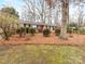 Well-maintained brick house with a landscaped front yard and a red front door at 3350 Bonneville Dr, Charlotte, NC 28205