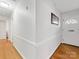 Hallway with hardwood flooring and white walls leading to the front door at 3350 Bonneville Dr, Charlotte, NC 28205