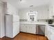 Clean white kitchen features modern stainless steel appliances, white cabinets, and hardwood floors at 3350 Bonneville Dr, Charlotte, NC 28205