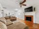 Spacious living room features a ceiling fan, hardwood floors, and a fireplace with a TV at 3350 Bonneville Dr, Charlotte, NC 28205