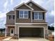 Two-story home featuring neutral siding, black shutters, and an attached two-car garage in a suburban community at 3362 Burberry Dr, Gastonia, NC 28052