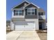 Two-story home with gray and white siding, black shutters, a two-car garage, and a concrete driveway at 3410 Saddlebred Dr, Gastonia, NC 28052