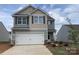 Charming two-story home featuring a two-car garage, gray siding and manicured landscaping at 3410 Saddlebred Dr, Gastonia, NC 28052