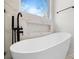 Freestanding bathtub and marble accent wall in an airy, modern bathroom at 4060 Steve Ikerd Ne Dr, Hickory, NC 28601