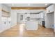 Open kitchen with quartz countertops, white cabinets, stainless steel appliances, and light hardwood floors at 4060 Steve Ikerd Ne Dr, Hickory, NC 28601
