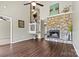 Open-concept living room with hardwood floors, a fireplace, and a staircase leading to the upper level at 4139 N Course Dr, Charlotte, NC 28277