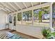 Relaxing screened-in porch with large windows offering views of the outdoors, plants and a cooling ceiling fan at 4139 N Course Dr, Charlotte, NC 28277