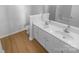 Bathroom featuring double sink vanity with white cabinetry and modern fixtures and wood-look flooring at 4219 Robinwood Dr, Charlotte, NC 28212