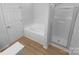 Bathroom featuring a large soaking tub, glass-enclosed shower, and wood-look flooring at 4219 Robinwood Dr, Charlotte, NC 28212