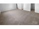 Open bedroom showing new neutral carpet, light filled space, and access to a closet and bathroom at 4219 Robinwood Dr, Charlotte, NC 28212