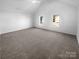 Spacious bedroom with vaulted ceilings, neutral carpet, and natural light from two windows at 4219 Robinwood Dr, Charlotte, NC 28212