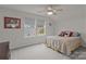 Bedroom featuring natural light, neutral carpet and a queen bed with dog-themed decor at 4720 Maiden Creek Way, Maiden, NC 28650