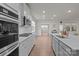 Open concept kitchen boasts stainless steel appliances, white cabinets, subway tile, and wood floors at 4720 Maiden Creek Way, Maiden, NC 28650