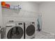 Neat laundry room with front load washer and dryer and overhead storage at 4720 Maiden Creek Way, Maiden, NC 28650