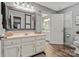Bathroom with a vanity featuring a large mirror, a door to an adjacent bathroom, and vinyl wood flooring at 5084 Mariana Ct, Tega Cay, SC 29708