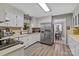 Bright kitchen featuring white cabinets, stainless steel appliances, and laminate flooring at 5084 Mariana Ct, Tega Cay, SC 29708