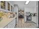 Well-lit kitchen with white cabinetry, modern appliances, and laminate floors at 5084 Mariana Ct, Tega Cay, SC 29708