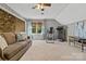 Spacious living room with stone fireplace, comfortable seating, and natural light from the window at 5084 Mariana Ct, Tega Cay, SC 29708