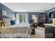 Well-appointed bedroom with blue walls, a large bed, access to a balcony, and comfortable sitting area at 5084 Mariana Ct, Tega Cay, SC 29708
