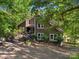 Beautiful home surrounded by mature trees, featuring white framed windows and a welcoming front entrance at 5084 Mariana Ct, Tega Cay, SC 29708