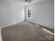 Bright bedroom featuring neutral carpeting, a ceiling fan, and a large window at 6318 Pink Dogwood Ln, Charlotte, NC 28262