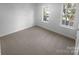 Bright bedroom featuring neutral carpeting and two windows, providing ample natural light at 6318 Pink Dogwood Ln, Charlotte, NC 28262