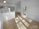 Hallway with vinyl flooring and white walls leading to a doorway and staircase in an open layout at 6318 Pink Dogwood Ln, Charlotte, NC 28262