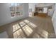 Spacious living room with vinyl flooring, abundant windows, and an open layout to the kitchen at 6318 Pink Dogwood Ln, Charlotte, NC 28262