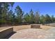 Beautiful backyard featuring a brick patio, tall trees, landscaping, and wrought iron fencing at 6521 Shoff Cir, Charlotte, NC 28215