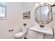 Stylish half-bathroom featuring a pedestal sink, framed mirror, and modern fixtures at 6521 Shoff Cir, Charlotte, NC 28215
