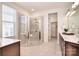 Well-lit bathroom with a glass-enclosed shower, double vanity, and neutral tile flooring at 6521 Shoff Cir, Charlotte, NC 28215