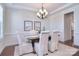 Elegant dining room with a chandelier, decorative wainscoting, and seating for six at 6521 Shoff Cir, Charlotte, NC 28215
