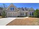 Charming single-Gathering home featuring a two-car garage, dormer windows, and a well-manicured lawn at 6521 Shoff Cir, Charlotte, NC 28215