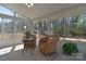 Inviting sunroom featuring large windows, wicker seating, a ceiling fan, and views of the backyard at 6521 Shoff Cir, Charlotte, NC 28215