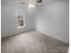 Bright bedroom with a ceiling fan features neutral carpet and a sunny window overlooking a backyard view at 6809 Brancusi Ct, Charlotte, NC 28215