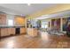 Open-concept living room featuring a kitchen island, hardwood floors, and large windows at 732 Ellsworth Rd, Charlotte, NC 28211