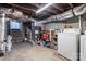 Unfinished basement with exposed ductwork, concrete walls, and a utility area with laundry appliances at 805 East St, Albemarle, NC 28001