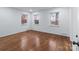 This bedroom is filled with natural light from three windows and hardwood floors at 805 East St, Albemarle, NC 28001