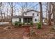 Charming two-story white home featuring a screened-in porch and a welcoming brick pathway at 805 East St, Albemarle, NC 28001