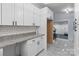 Well-lit kitchen features white cabinets, granite countertops, and tile flooring at 805 East St, Albemarle, NC 28001