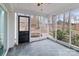 Enclosed sunroom featuring slate floors, white accents, and backyard access at 805 East St, Albemarle, NC 28001