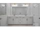 A modern bathroom features dual vanities, brushed bronze fixtures, and marble look tile at 8233 Houser St, Cornelius, NC 28031