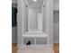 Mudroom features storage bench with white cabinets and a large decorative mirror at 8233 Houser St, Cornelius, NC 28031