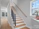 Bright staircase with wood treads, black metal railings, and large window at 8233 Houser St, Cornelius, NC 28031