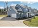 View of home showcasing three-car garage and neatly landscaped yard with a sidewalk at 8638 Raven Top Dr, Mint Hill, NC 28227